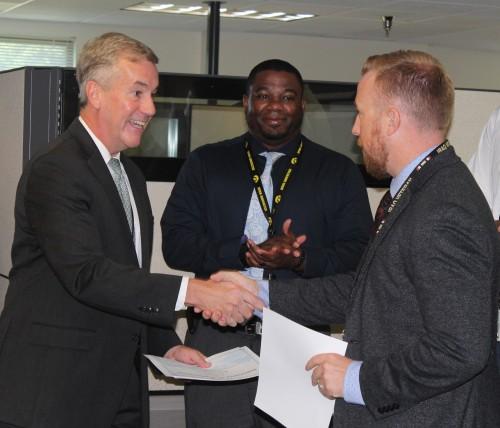 Col. Harris presents civilian employees with certificates of appreciation.