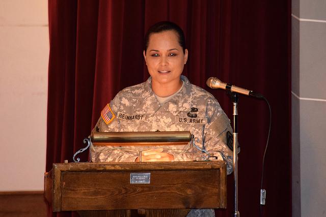 Soldier addresses crowd from behind podium.